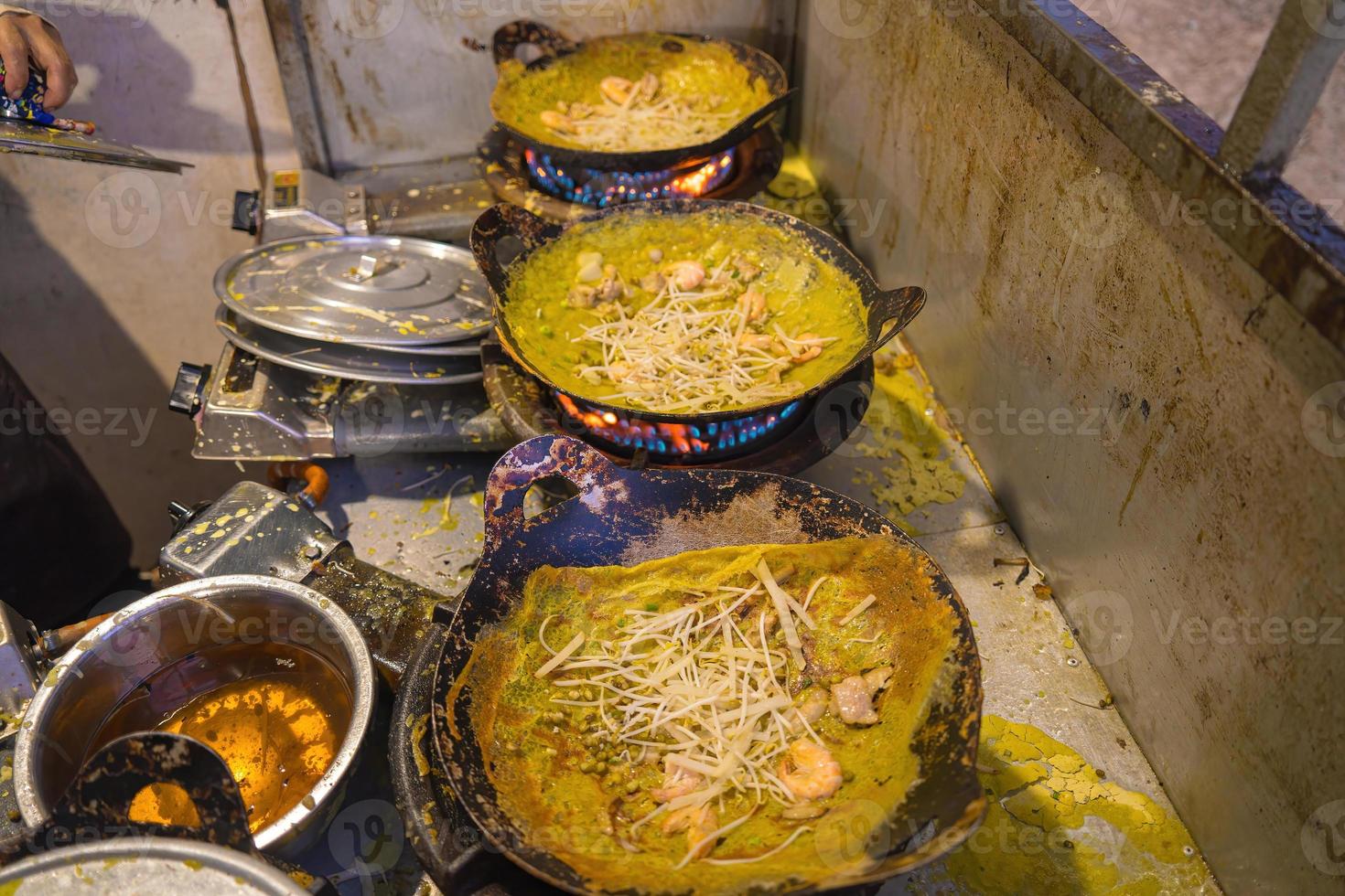 des crêpes banh xeo vietnamiennes remplies de porc ou de poulet peuvent également, des crevettes, des oignons et des germes de soja, et de la sauce piquante placée près de l'assiette sur la table photo