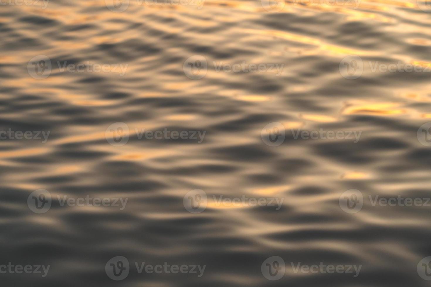 l'eau du coucher du soleil reflète les ondulations à la lumière du soleil. réflexion dorée abstraite sur le coucher du soleil sur l'eau photo