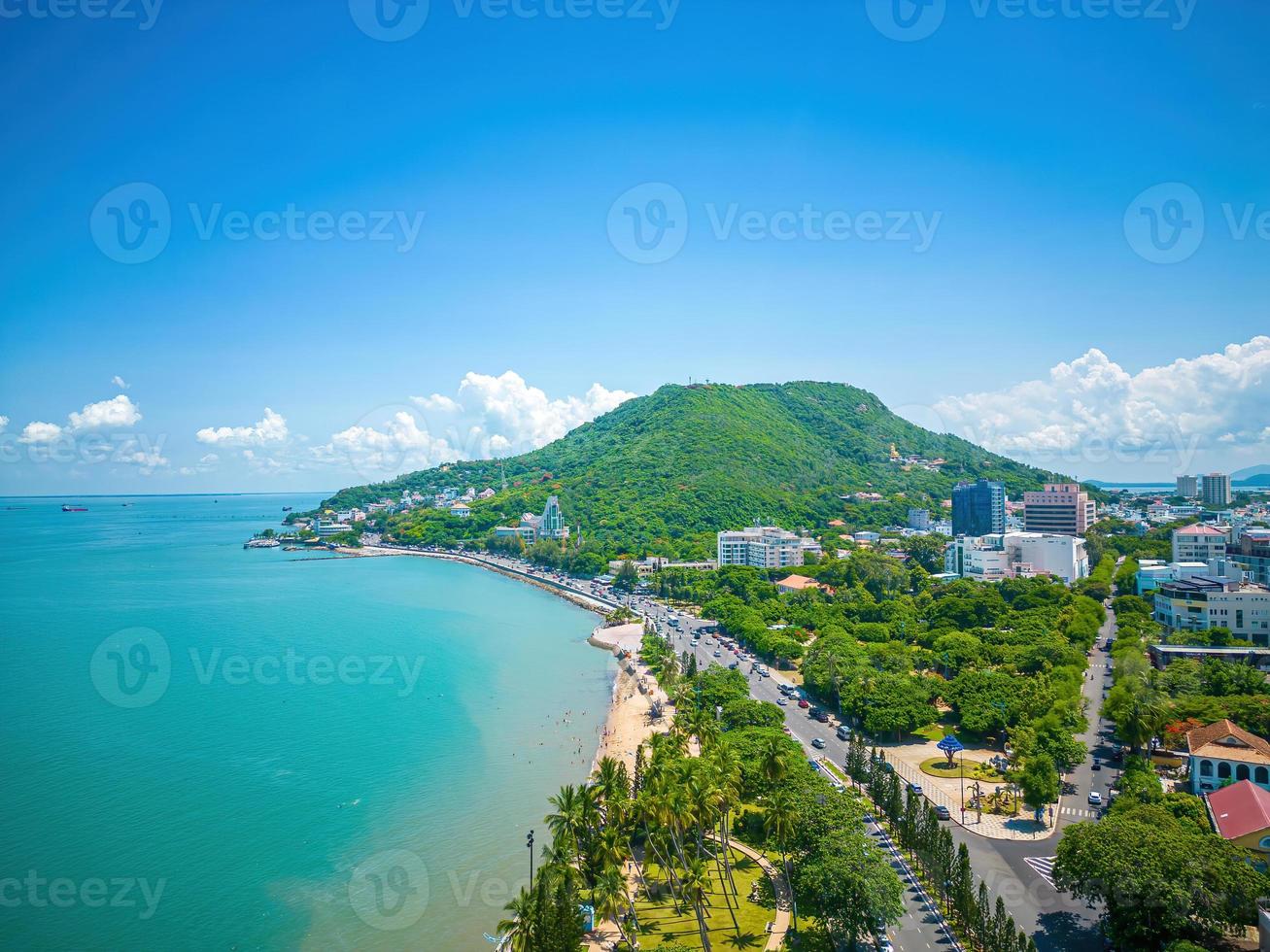 vue aérienne de la ville de vung tau avec un beau coucher de soleil et tant de bateaux. vue panoramique sur la côte vung tau d'en haut, avec vagues, littoral, rues, cocotiers et montagne tao phung au vietnam. photo