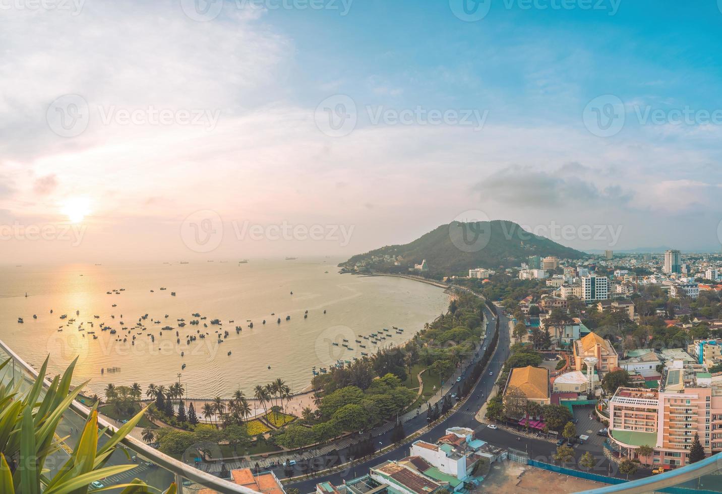 vue aérienne de la ville de vung tau avec un beau coucher de soleil et tant de bateaux. vue panoramique sur la côte vung tau d'en haut, avec vagues, littoral, rues, cocotiers et montagne tao phung au vietnam. photo