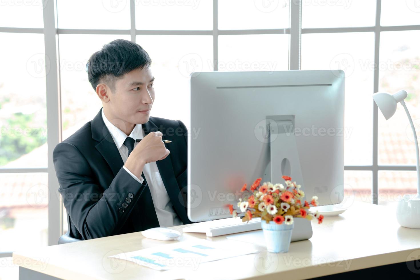 employé de bureau réfléchi pensant à la solution du problème en regardant l'ordinateur photo