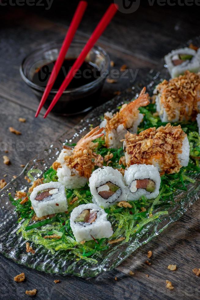 sushis au thon et crevettes sur lit de salade d'algues vertes photo