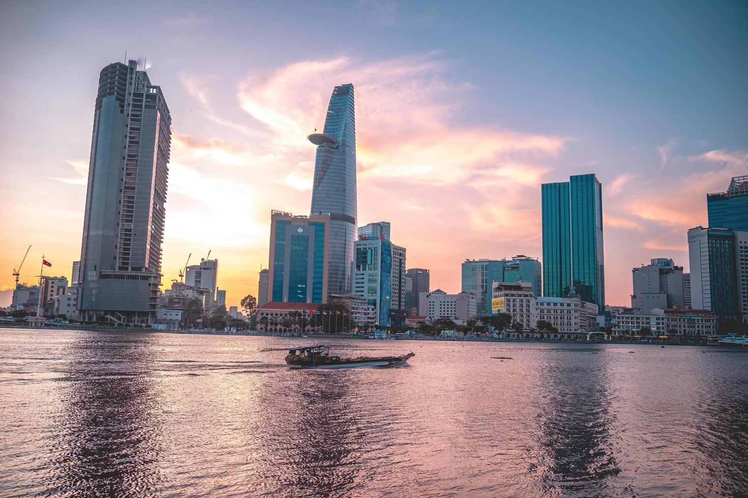 ho chi minh, vietnam - 13 février 2022 vue sur le bâtiment de la tour financière bitexco, les bâtiments, les routes, le pont thu thiem et la rivière saigon à ho chi minh ville au coucher du soleil. image panoramique de haute qualité. photo