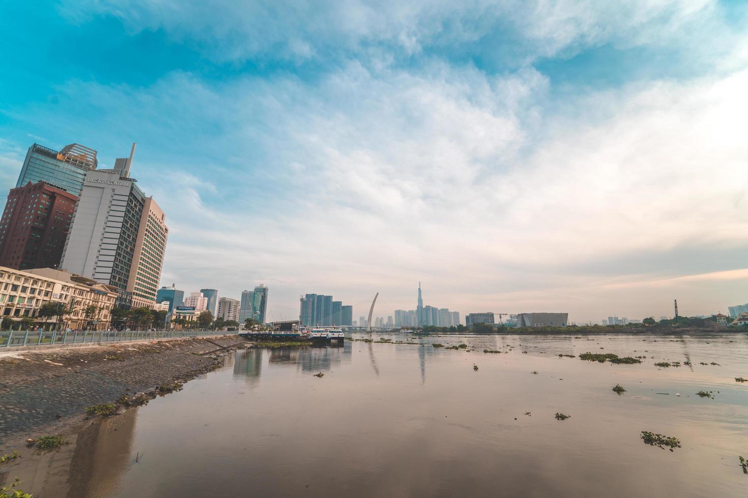 ho chi minh ville, vietnam - 12 février 2022 skyline avec le gratte-ciel historique 81, un nouveau pont à haubans est en train de construire reliant la péninsule de thu thiem et le district 1 de l'autre côté de la rivière saigon. photo