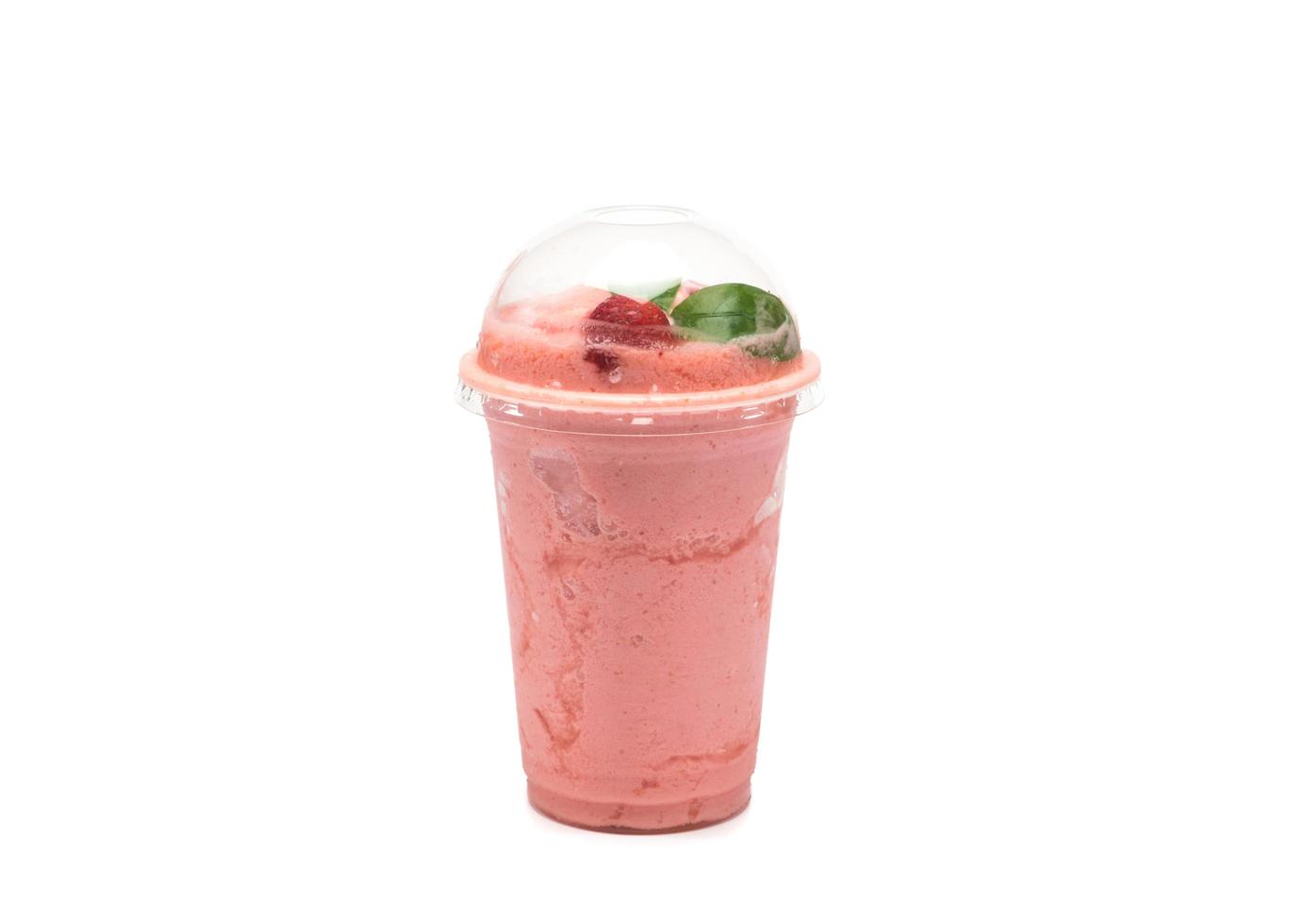 smoothie aux fraises dans une tasse transparente en plastique sur fond blanc photo