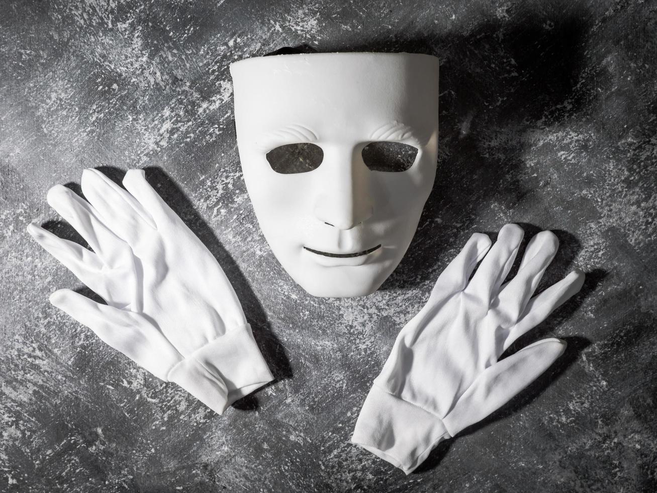 masque blanc avec gant sur fond gris grunge. photo