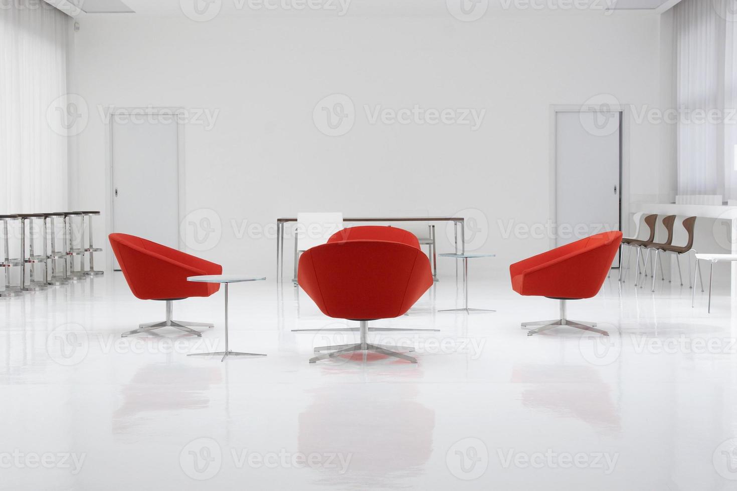 un loft moderne avec des chaises rouges et des murs blancs photo