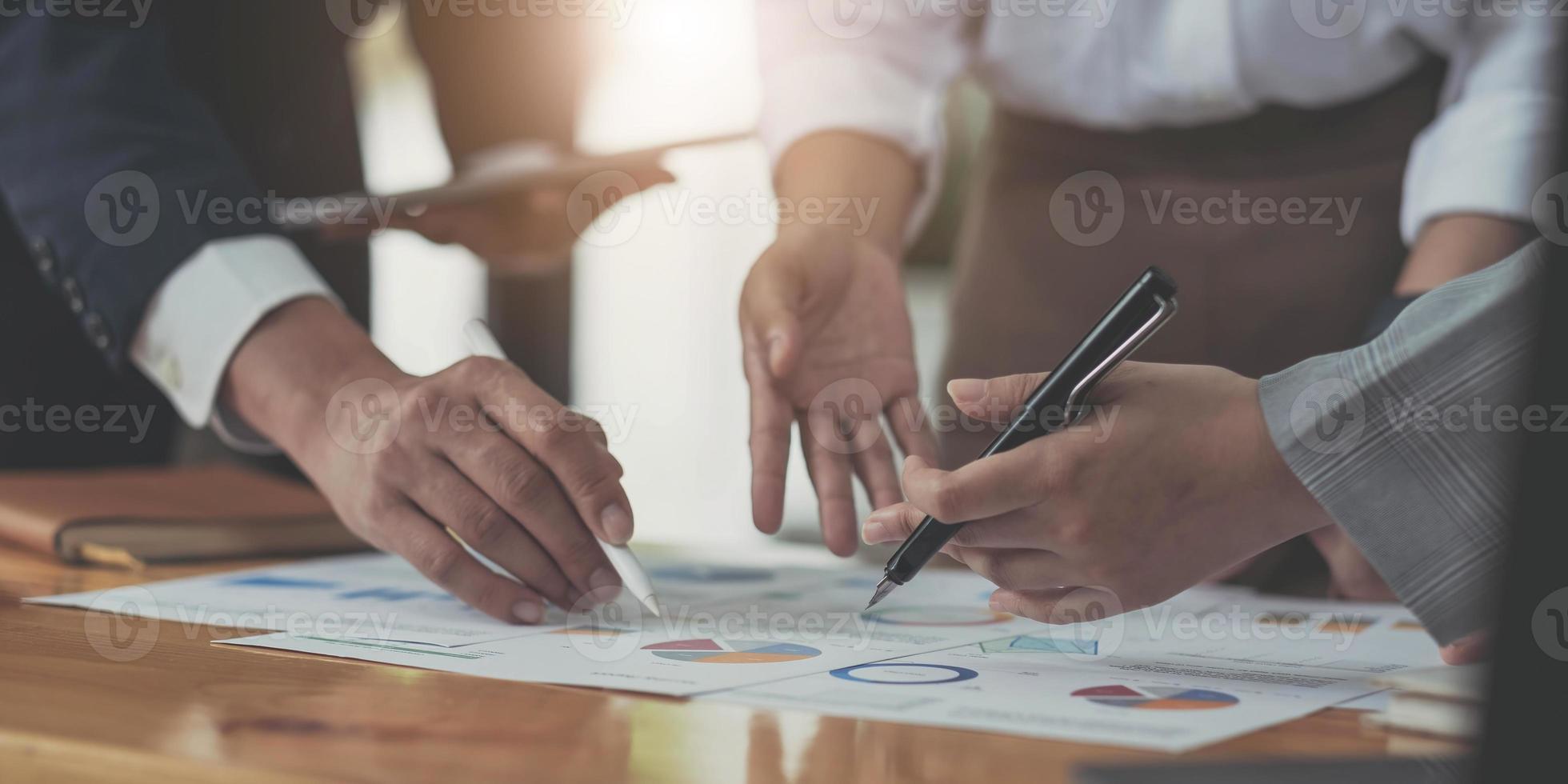 processus de travail de l'équipe photo, tenant la main du contrat, signe les documents. le jeune équipage des gestionnaires de compte travaille avec le projet de démarrage. Une nouvelle présentation d'idée, analyse les rapports marketing. flou, effet de film, horizontal photo