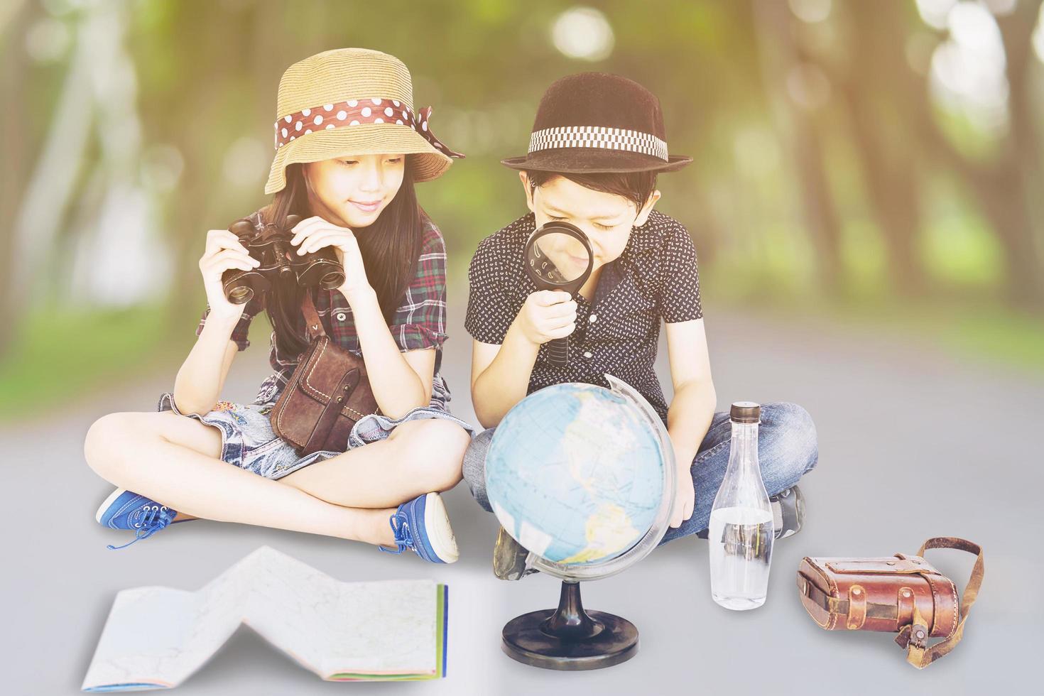 les voyageurs asiatiques garçon et fille étudient la carte du monde se préparent à partir photo