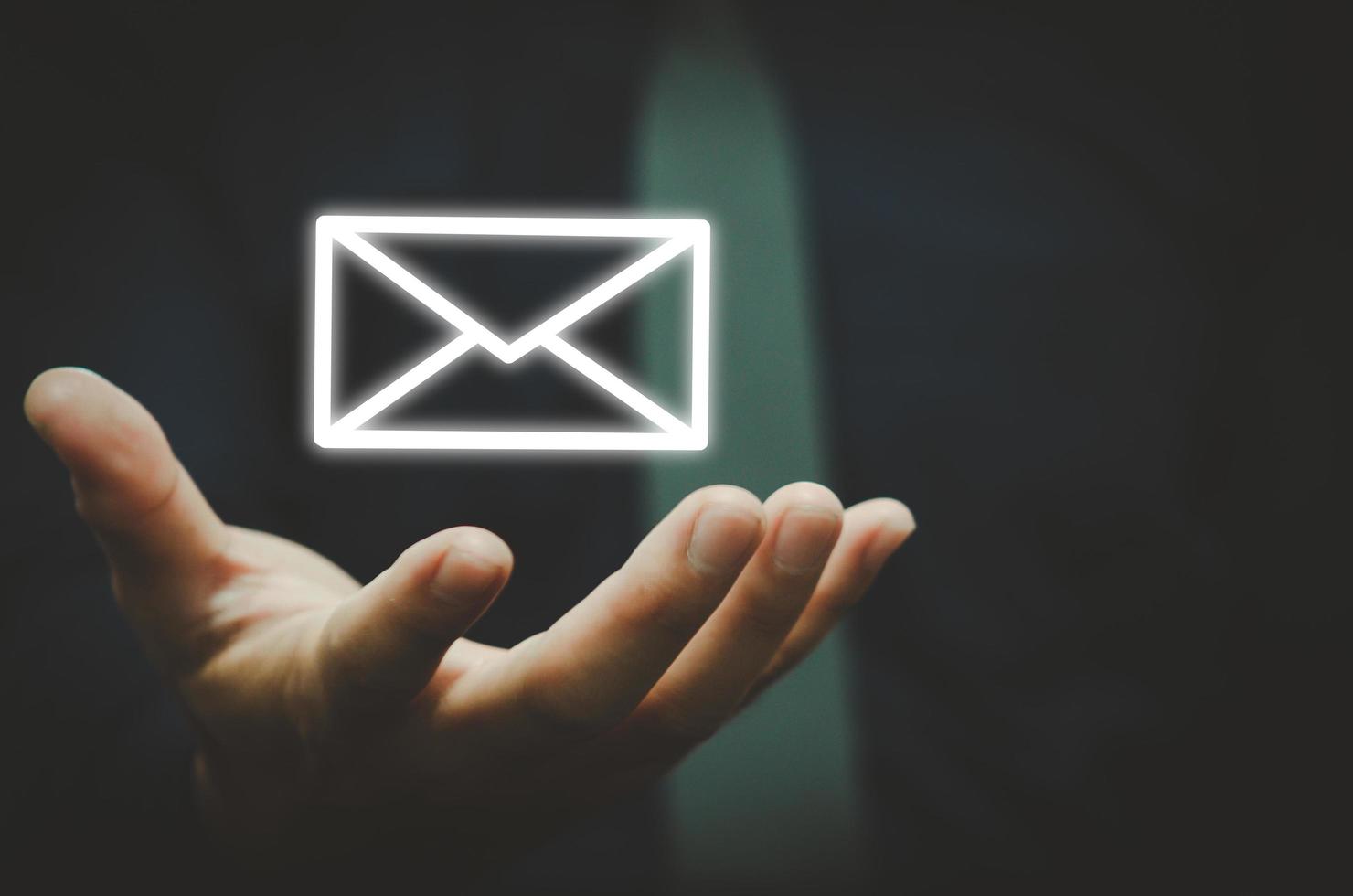 homme d'affaires détenant l'icône e-mail contactez-nous par e-mail newsletter. et protégez vos informations personnelles contre les spams. centre de service client contactez-nous concept. photo