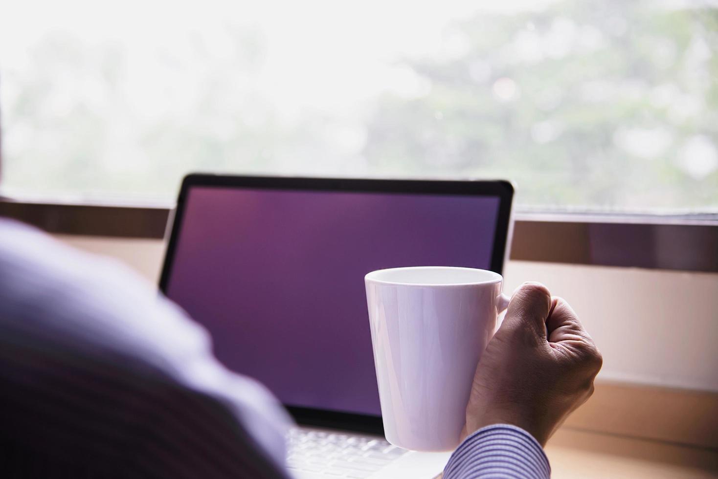 homme d'affaires travaillant avec un ordinateur avec une tasse de café dans la chambre d'hôtel - concept de mode de vie des personnes travaillant photo