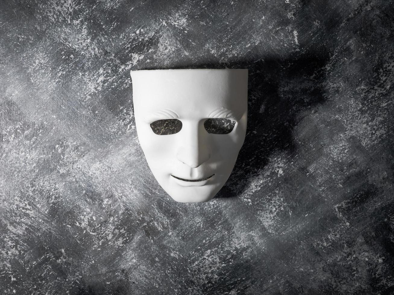 masque blanc sur fond gris grunge. photo