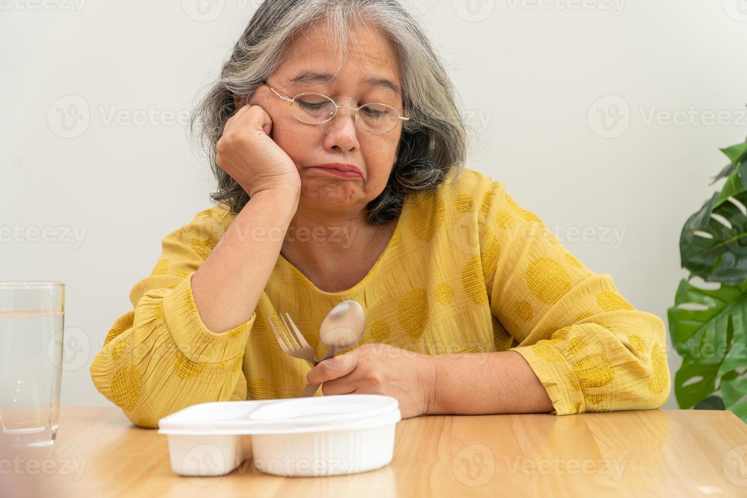 femme âgée asiatique malheureuse anorexie et dire non aux plats préparés, maison âgée seule et nourriture ennuyée et pas d'appétit photo