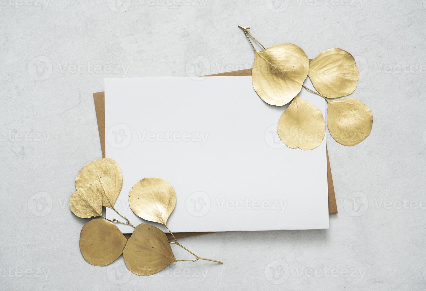 maquette pour une lettre ou une invitation de mariage avec des branches d'eucalyptus en feuilles d'or. photo