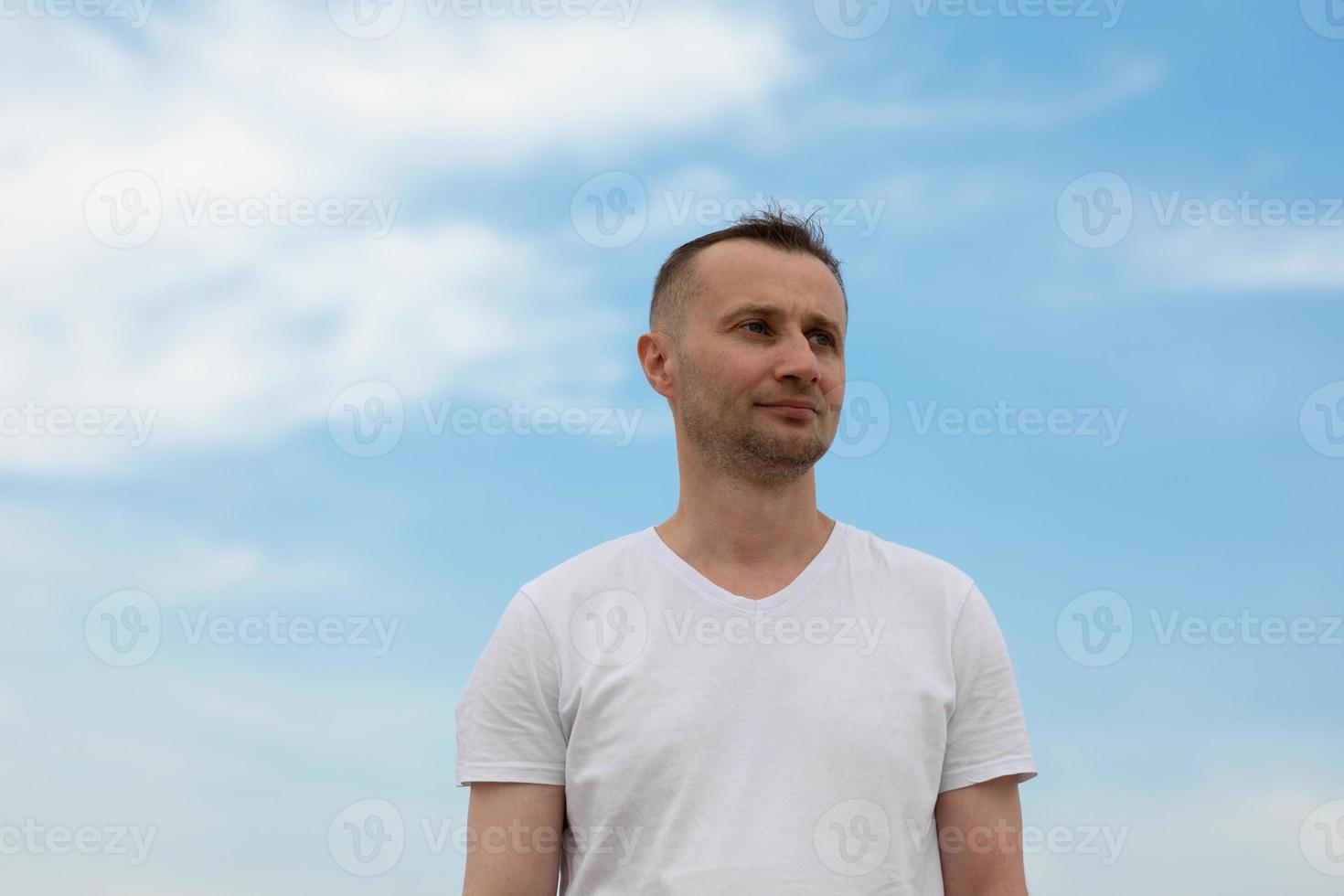 jeune homme contre le ciel bleu photo