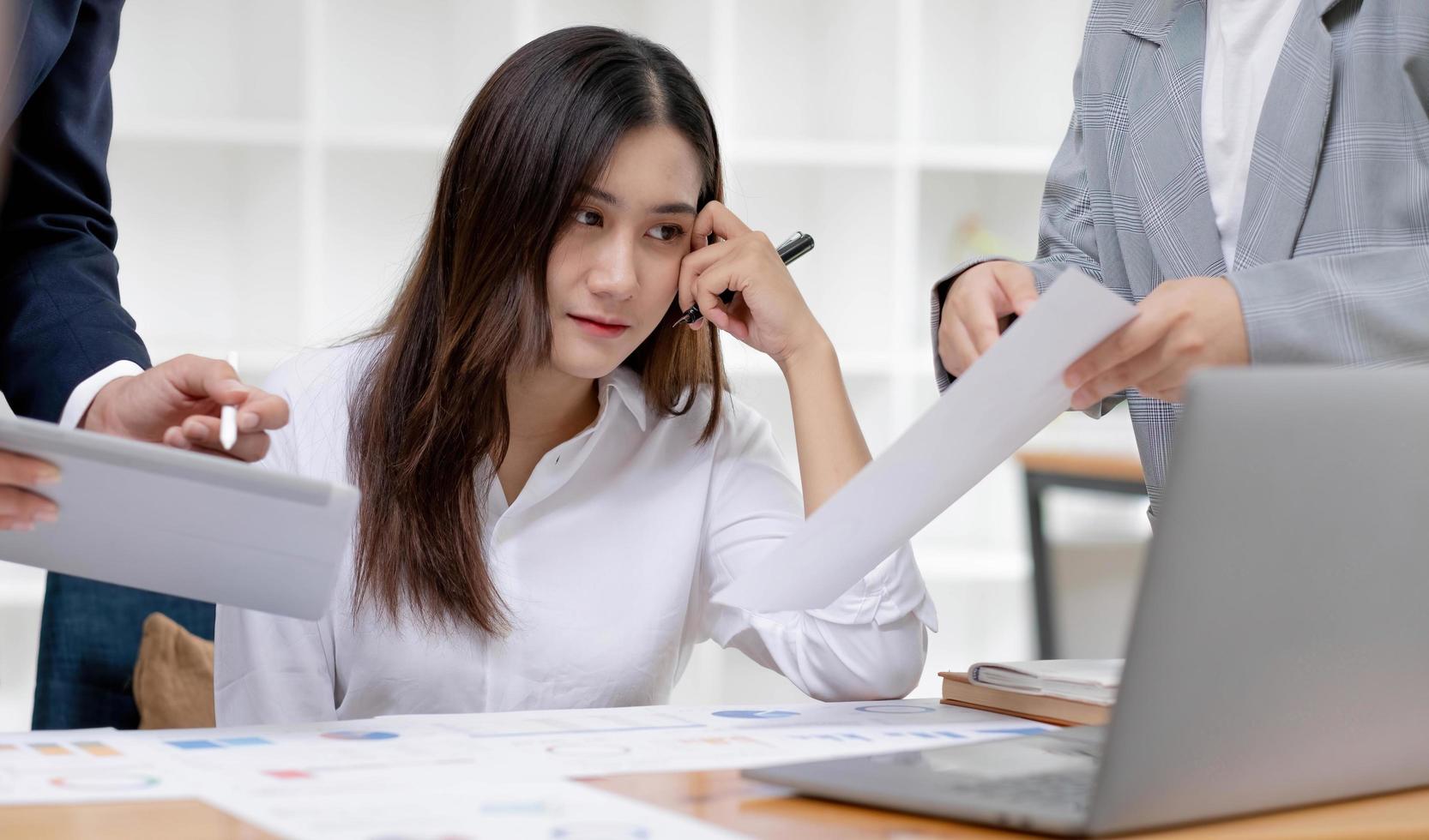 belle femme d'affaires asiatique millénaire ou travailleuse financière travaillant et remue-méninges avec son collègue au bureau. photo