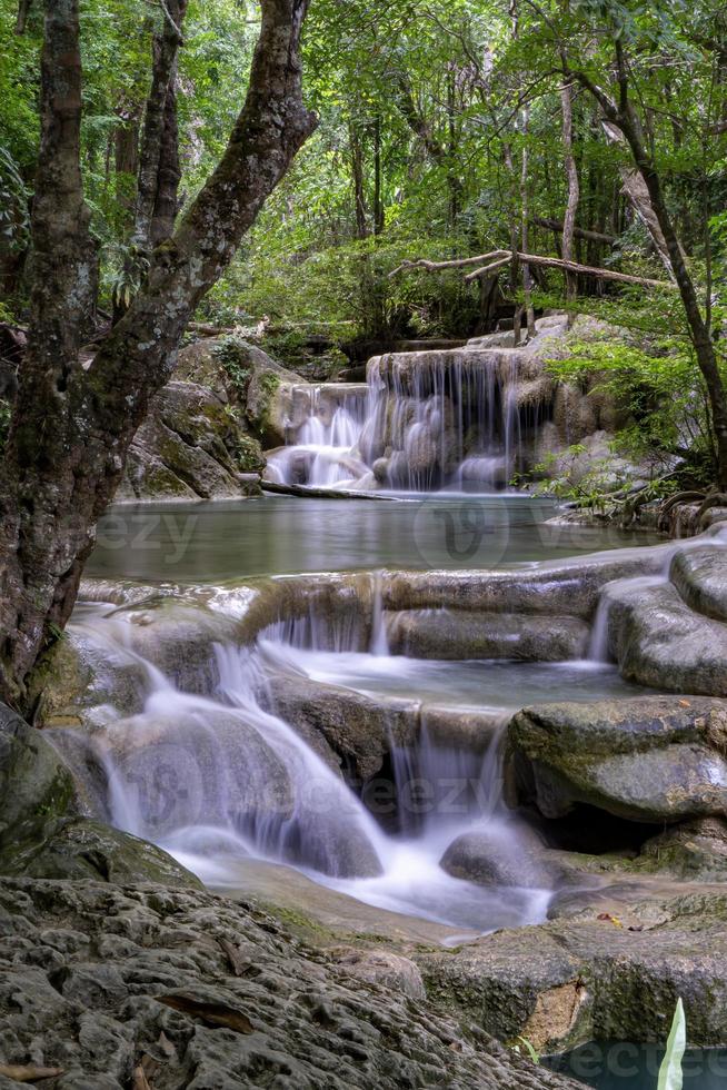 eau verte émeraude propre de la cascade entourée de petits arbres - grands arbres, couleur verte, cascade d'erawan, province de kanchanaburi, thaïlande photo