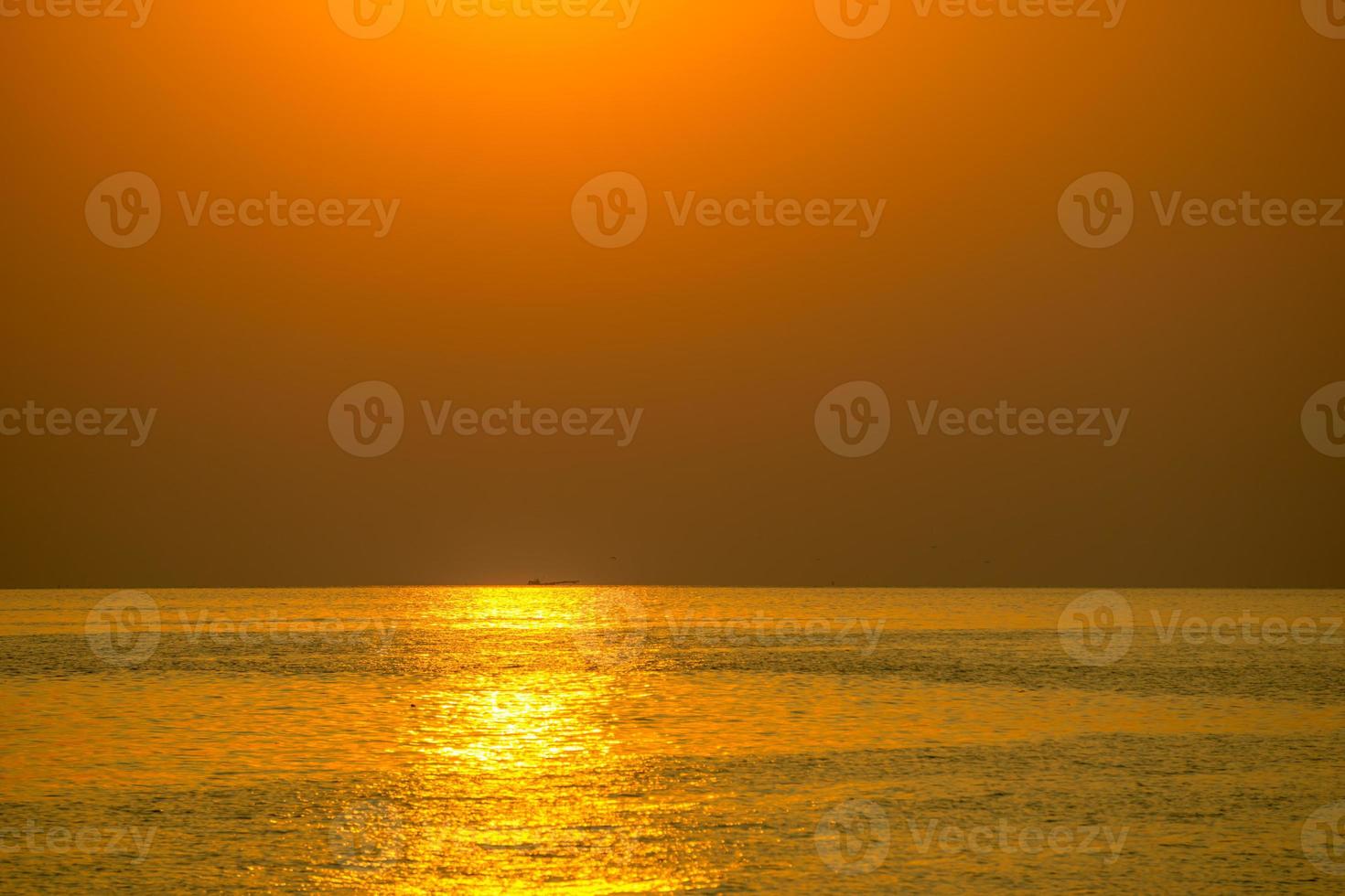 e soleil est tombé le soir. couleur dorée brillante, reflétant l'eau de mer photo