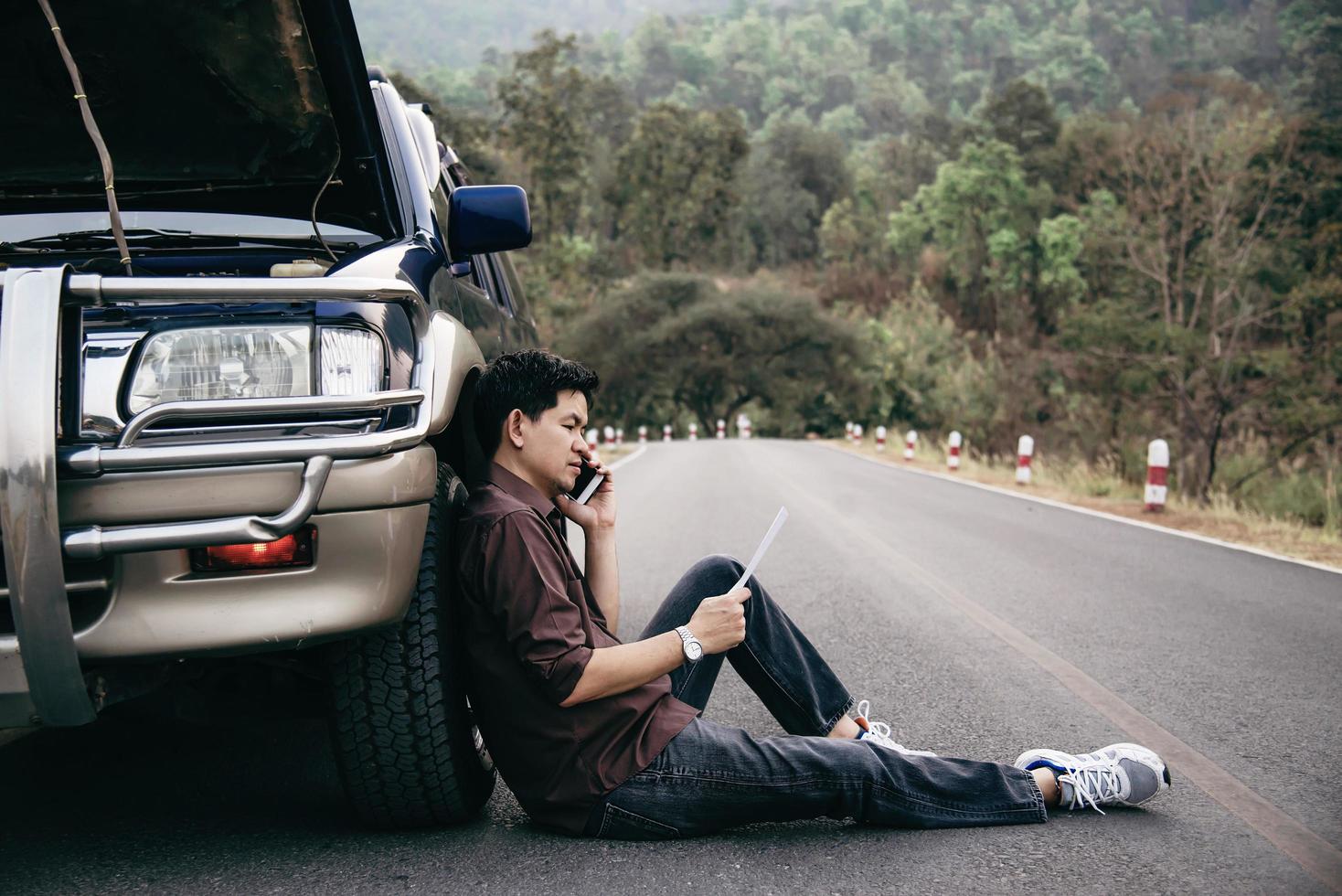 un homme essaie de résoudre un problème de moteur de voiture sur une route locale chiang mai thaïlande - les personnes ayant un problème de voiture concept de transport photo