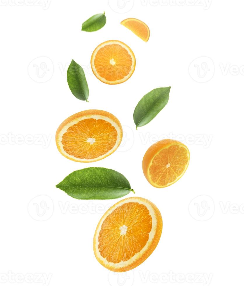 tomber des oranges juteuses avec des feuilles vertes isolées sur fond transparent. voler des tranches d'oranges défocalisées. applicable pour la publicité sur les jus de fruits photo