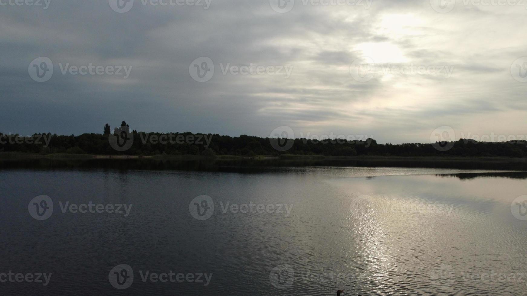 image aérienne et en grand angle de jolis oiseaux d'eau nagent dans le lac stewartby d'angleterre royaume-uni par beau petit matin au lever du soleil photo