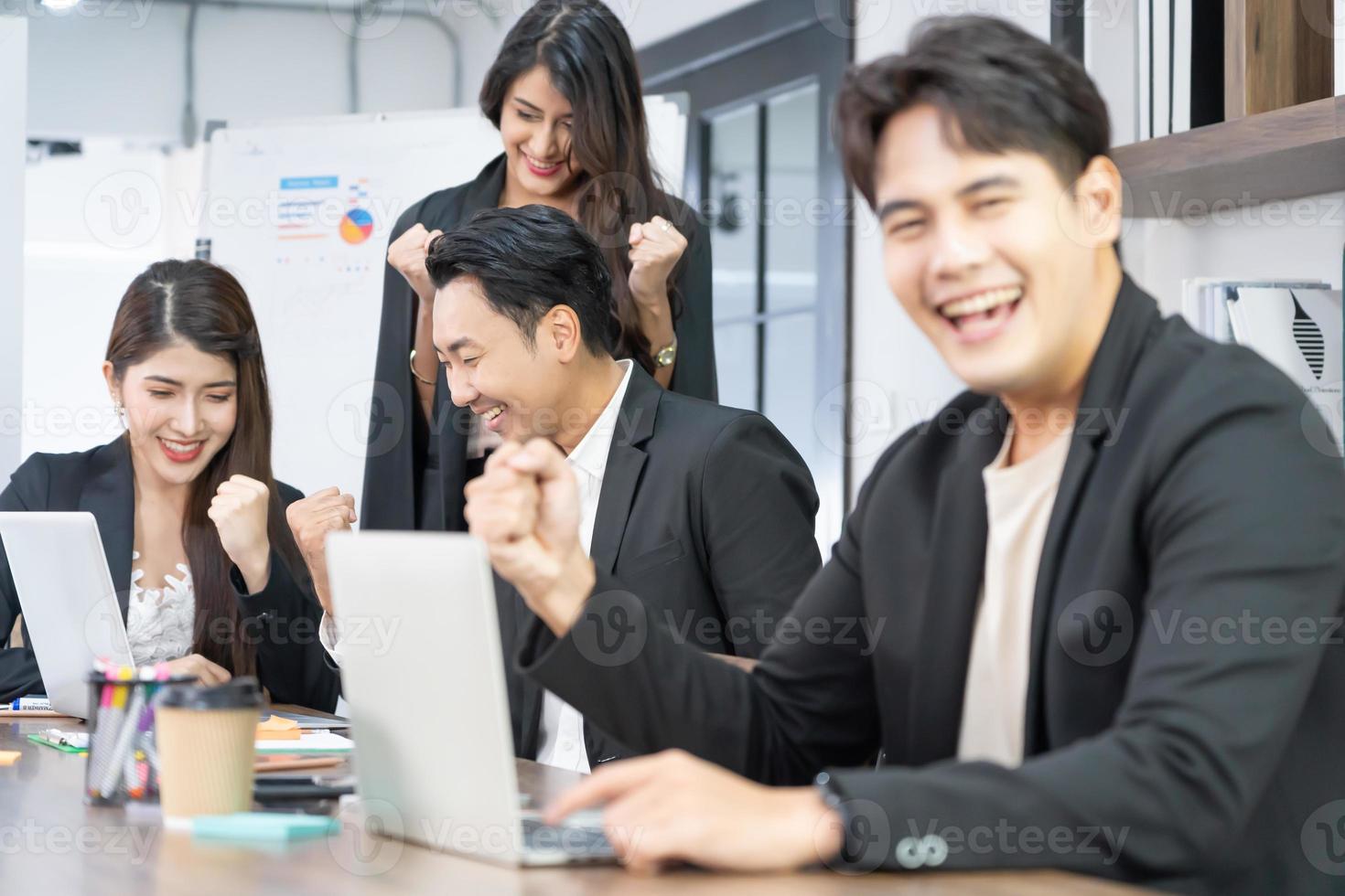 hommes d'affaires triomphant en raison de la croissance financière de l'entreprise. heureux hommes d'affaires souriants triomphant avec les poings levés. photo