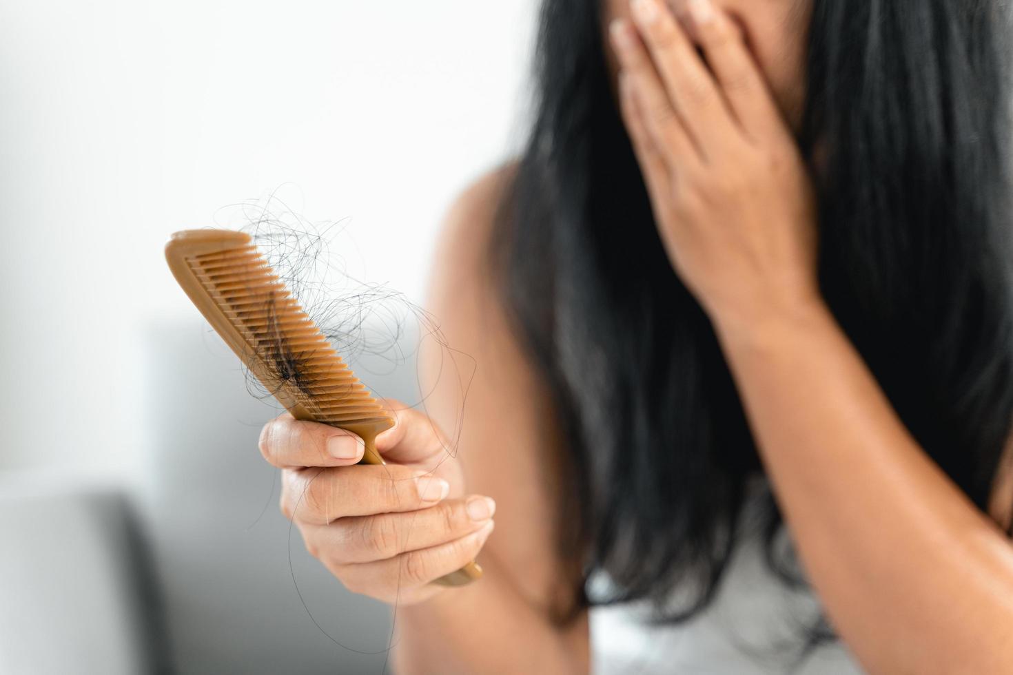 problème de chute de cheveux. femme asiatique avec problème de peigne et de cheveux. perte de cheveux du peigne. concepts de soins capillaires et de beauté. photo