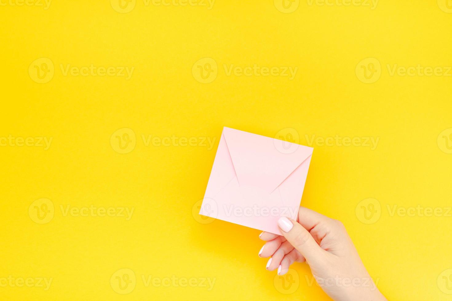 main de femme avec enveloppe rose photo