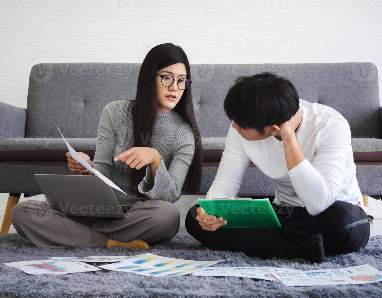 homme d'affaires couple, femme et homme assis ensemble à la maison à l'aide d'un ordinateur portable pour une réunion en ligne avec le travail d'équipe de démarrage. jeune femme d'affaires asiatique travaillant, planifiant ou discutant avec un collègue. photo