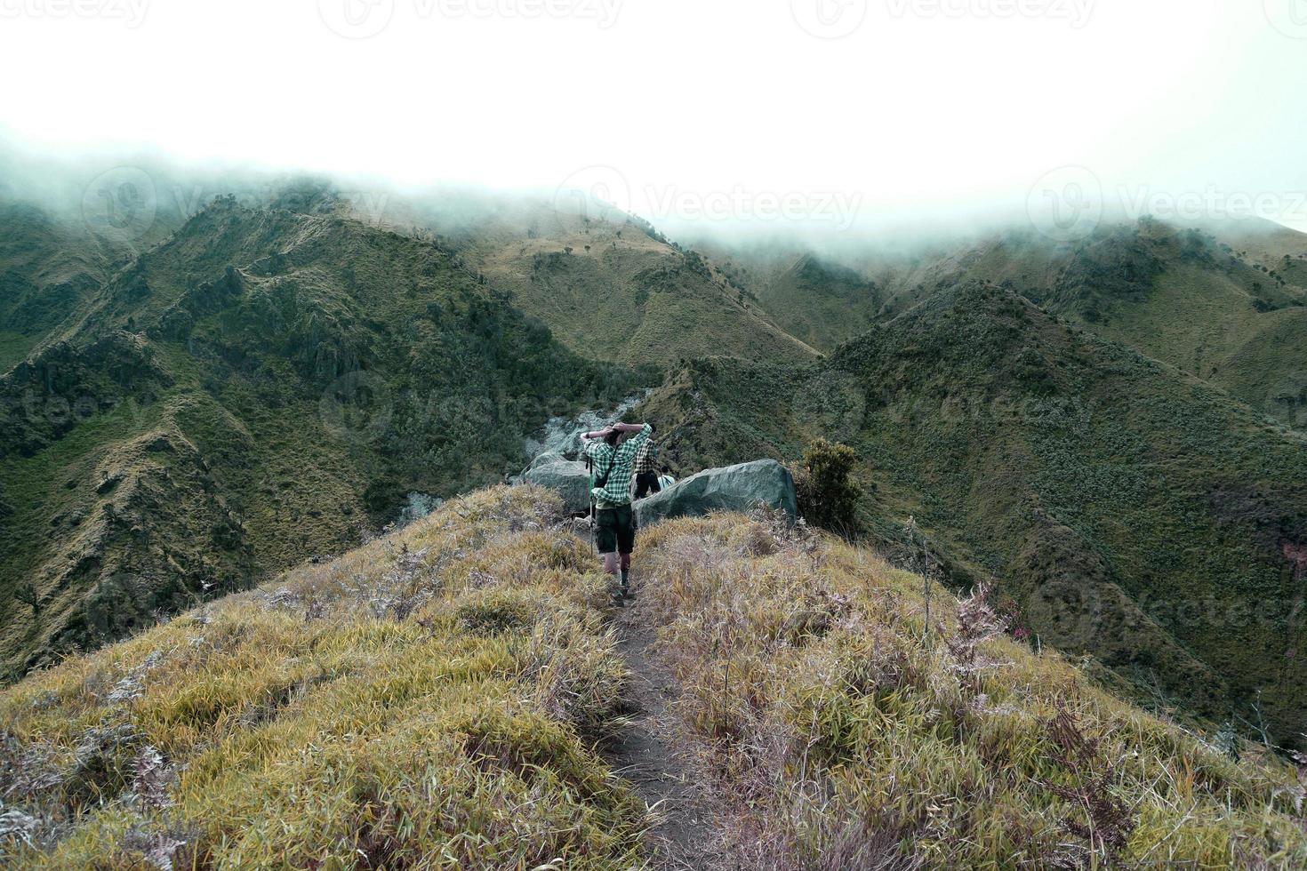 les aventuriers marchent vers les montagnes couvertes de nuages photo