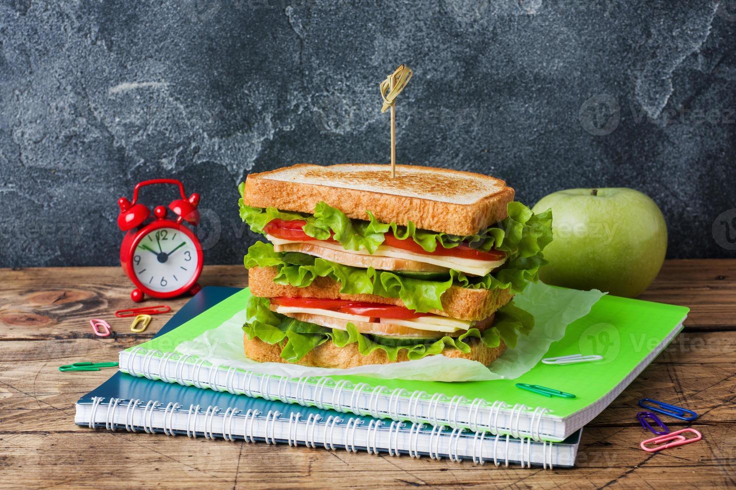 déjeuner sain pour l'école avec sandwich, pomme fraîche. fournitures scolaires colorées assorties. espace de copie. photo