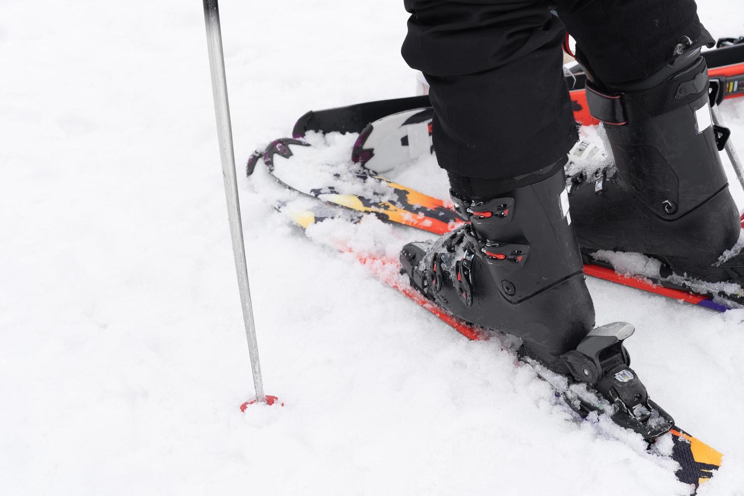 gros plan de la jambe sur la planche de ski et le poteau. photo