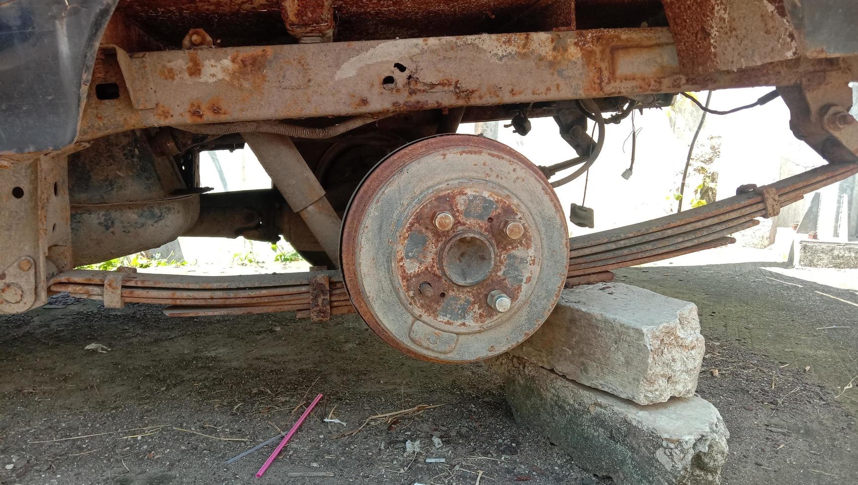 la jante du pneu de voiture est rouillée, elle est coincée avec un rocher photo