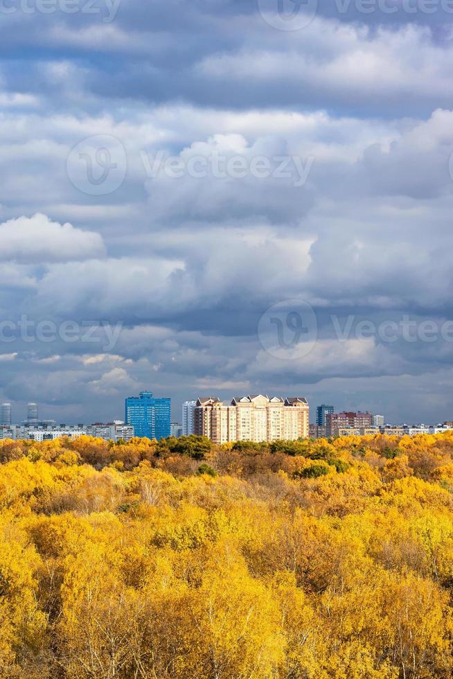 nuages pluvieux sur la forêt jaune et les maisons modernes photo