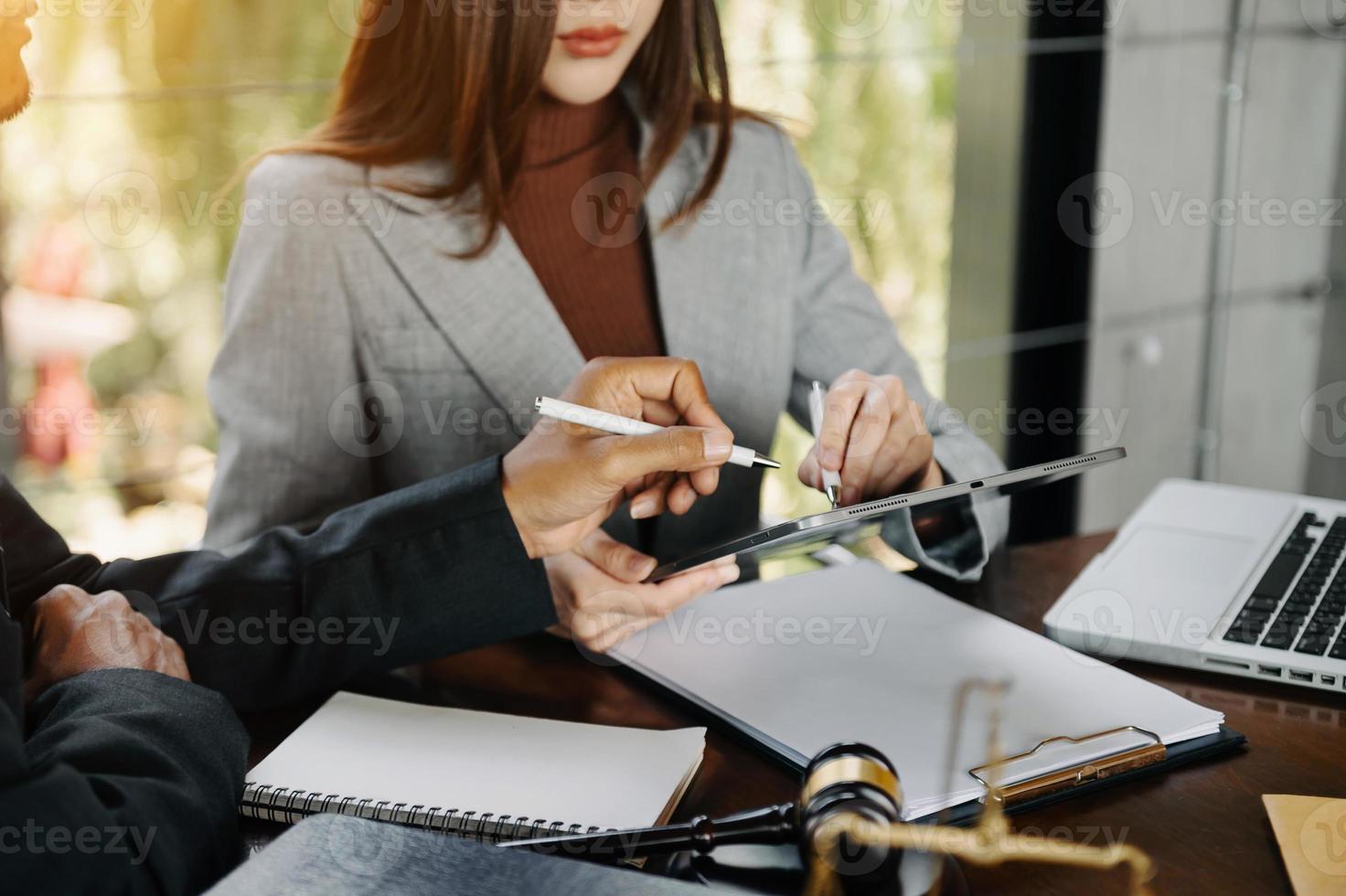 des hommes d'affaires et des avocats discutant des documents contractuels assis à la table. notions de droit, conseils, services juridiques. à la lumière du matin photo