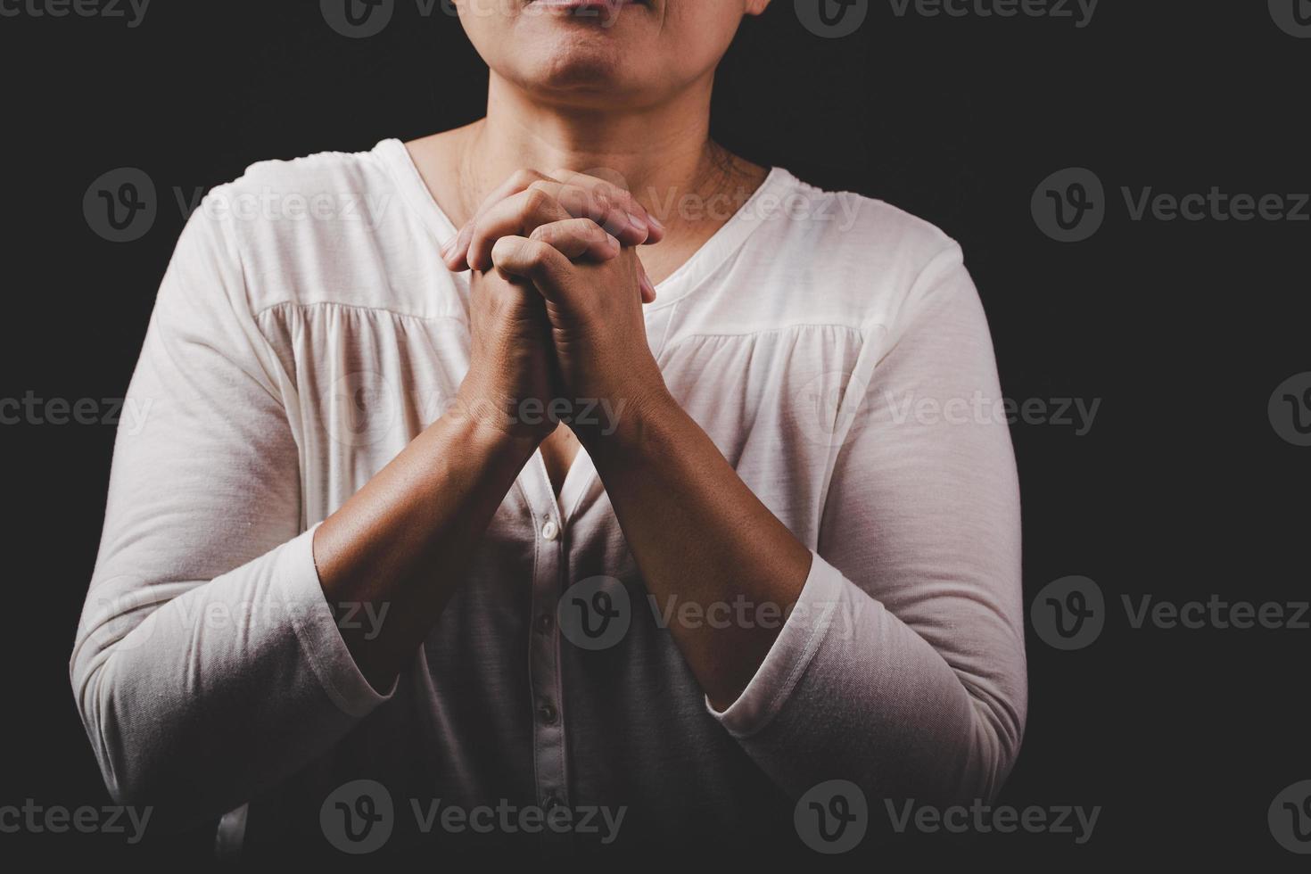 la main de la femme chrétienne sur la sainte bible prie et adore Dieu merci à l'église avec fond noir, concept pour la foi, la spiritualité et la religion photo