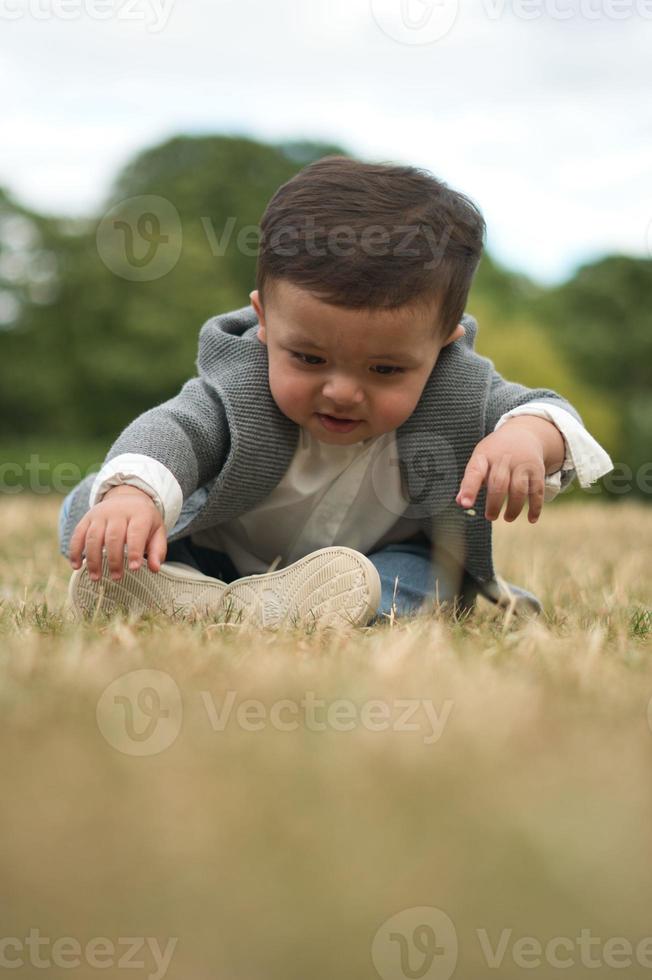 Mignon petit bébé bébé pose dans un parc public local de la ville de Luton en Angleterre Royaume-Uni photo