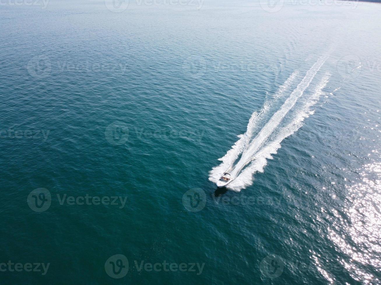 images en grand angle et vue aérienne de l'océan avec des bateaux à grande vitesse, les gens s'amusent et profitent du temps le plus chaud sur le front de mer de la plage de bournemouth en angleterre au royaume-uni. photo