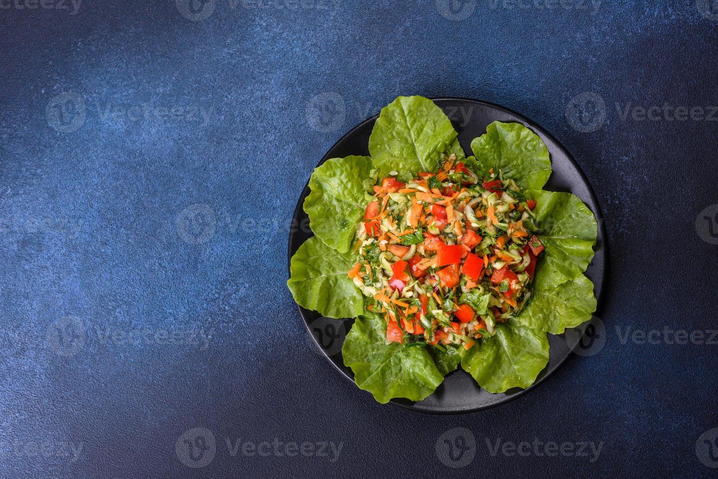 assiette de salade de légumes et de verdure sur une table en béton foncé photo