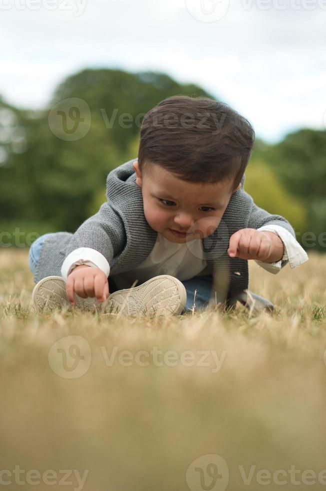 Mignon petit bébé bébé pose dans un parc public local de la ville de Luton en Angleterre Royaume-Uni photo