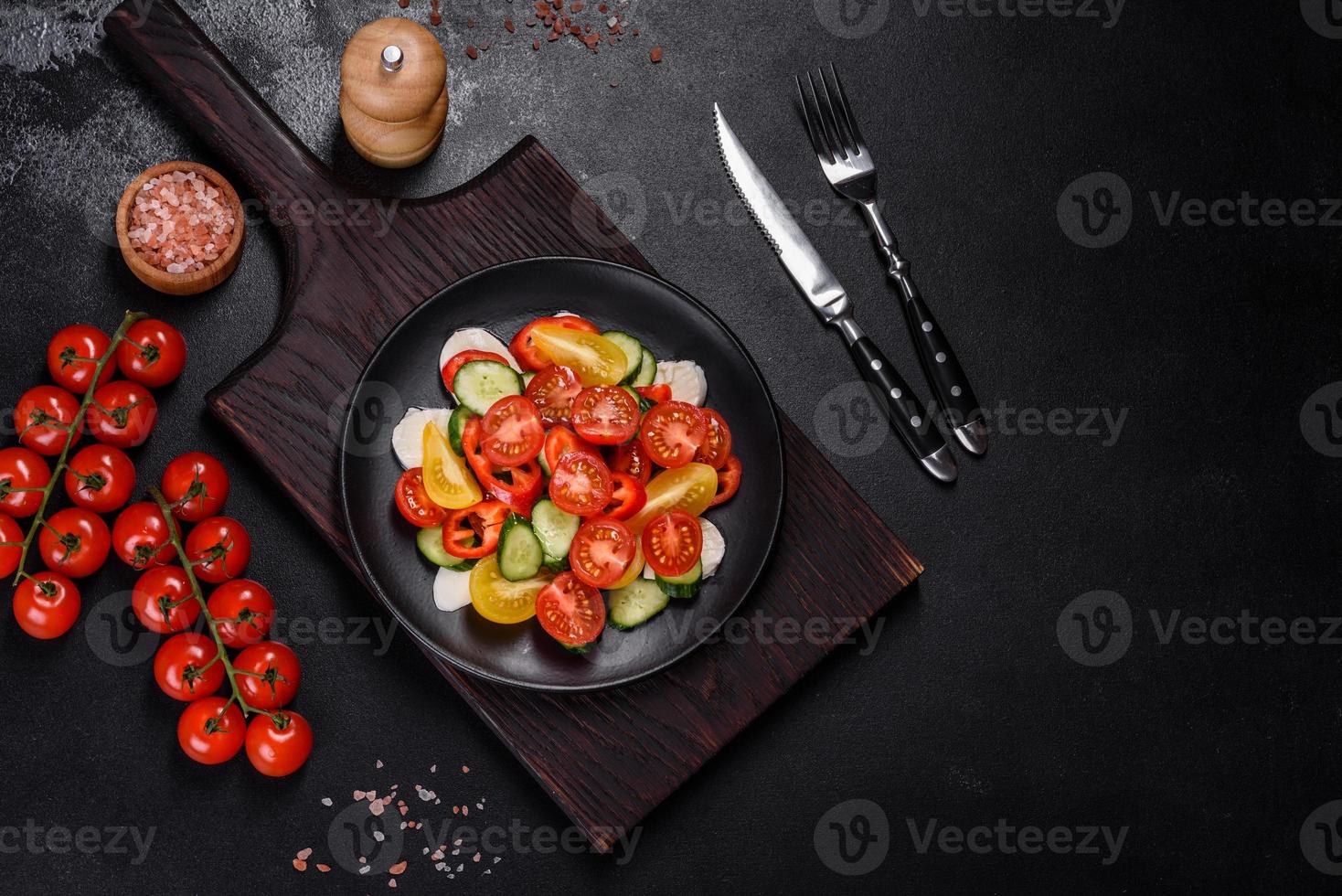 salade fraîche et délicieuse avec tomates cerises, concombres, poivrons, fromage et huile d'olive photo