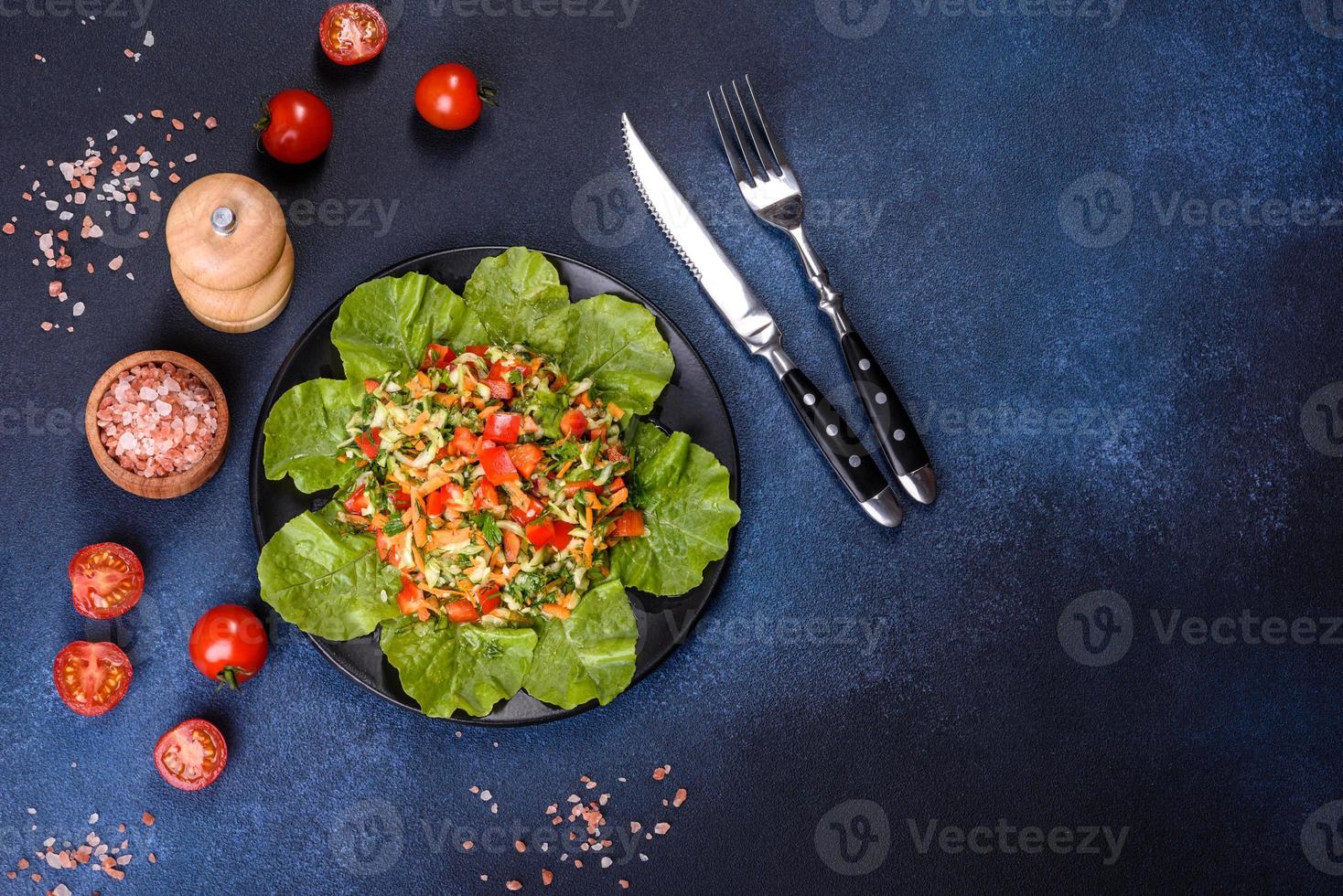 assiette de salade de légumes et de verdure sur une table en béton foncé photo