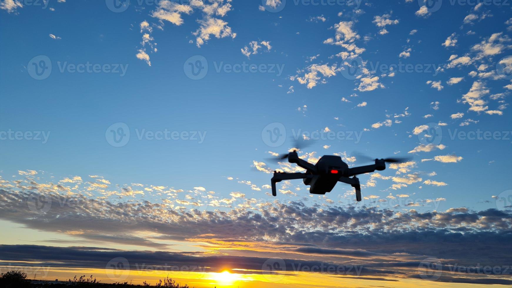 un drone vole au coucher du soleil magnifique et coloré avec des nuages sur le ciel photo