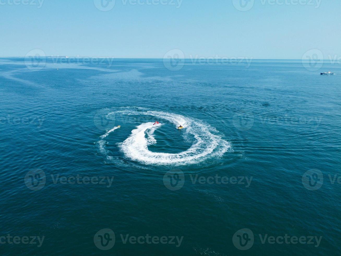 images en grand angle et vue aérienne de l'océan avec des bateaux à grande vitesse, les gens s'amusent et profitent du temps le plus chaud sur le front de mer de la plage de bournemouth en angleterre au royaume-uni. photo