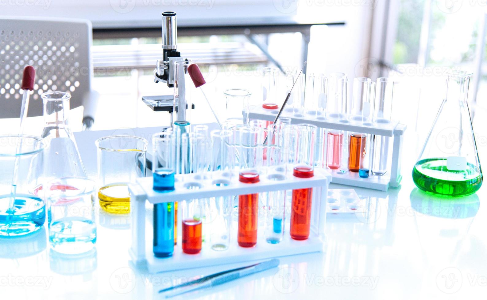 préparation d'équipements de laboratoire tels que verrerie, tube avec bleu et liquide sur la table blanche. l'expérience de chimie dans la recherche scientifique photo