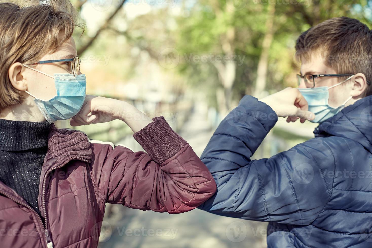 amis gars et fille démontrant une nouvelle façon de saluer pendant l'épidémie de coronavirus. photo