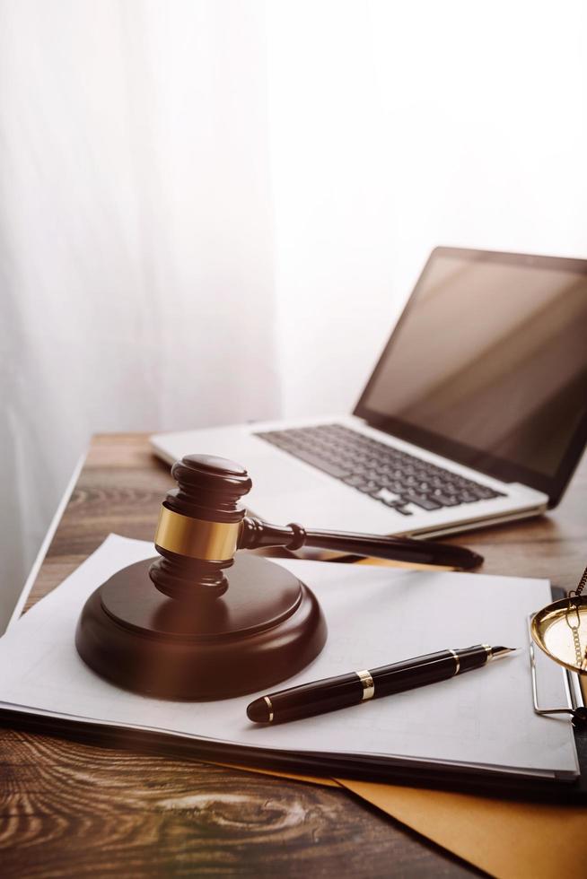 concept de justice et de droit. juge masculin dans une salle d'audience avec le marteau, travaillant avec, clavier d'ordinateur et d'accueil, lunettes, sur table à la lumière du matin photo