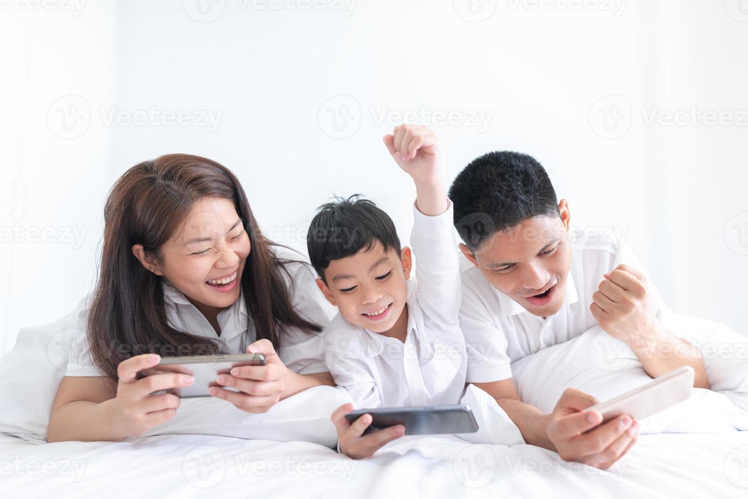 portrait famille heureuse maman papa et fils souriant dans la chambre à coucher. se regarder. photo