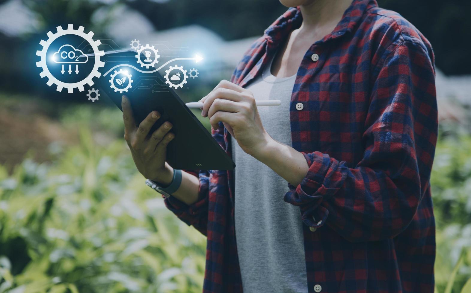 un homme d'affaires futuriste cultive des légumes et des cultures à l'aide de la technologie ai moderne utilisant des téléphones portables, des capteurs de température et d'humidité, le suivi de l'eau, le contrôle du climat, des icônes de données de données holographiques. photo