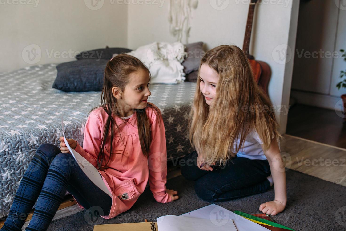 deux amies jouent à la maison, dessinent avec des crayons et des feutres et s'amusent photo